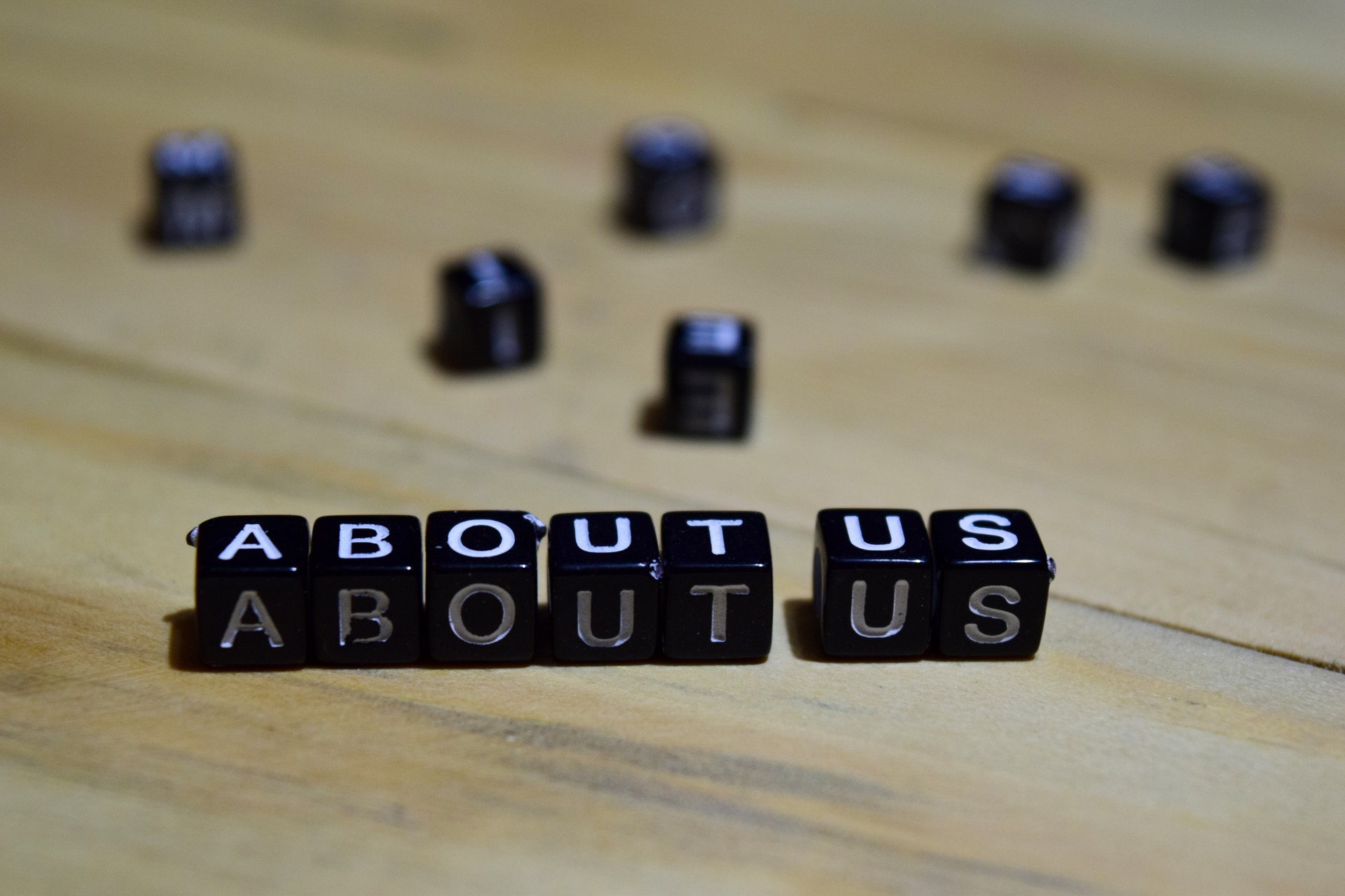 About us message written on wooden blocks.